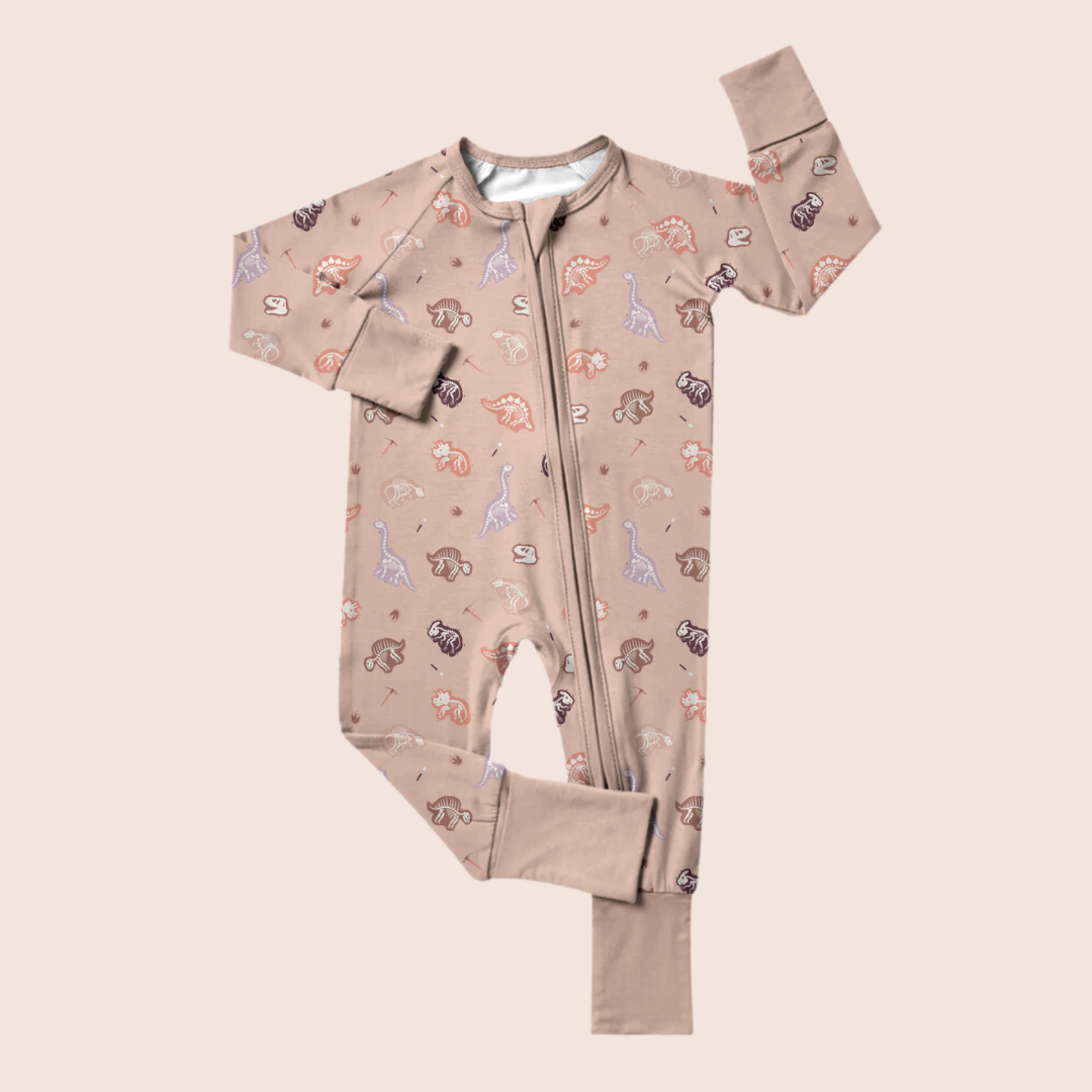 Dinosaur baby onesie flat lay — organic cotton with paleontology print