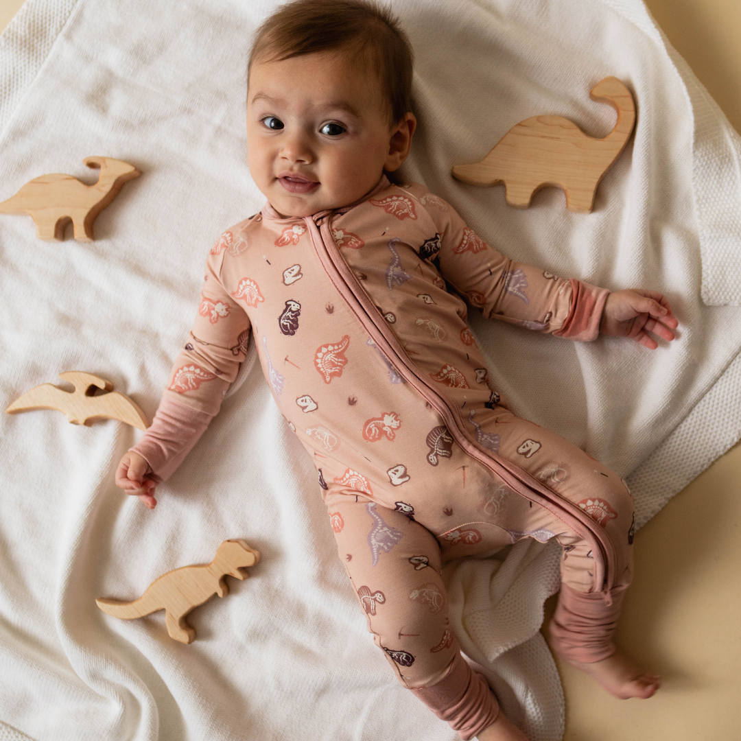 Baby wearing dinosaur-themed onesie — The Anning organic cotton bodysuit