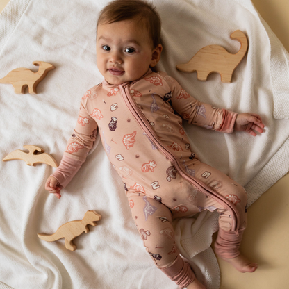 Baby wearing dinosaur-themed onesie — The Anning organic cotton bodysuit