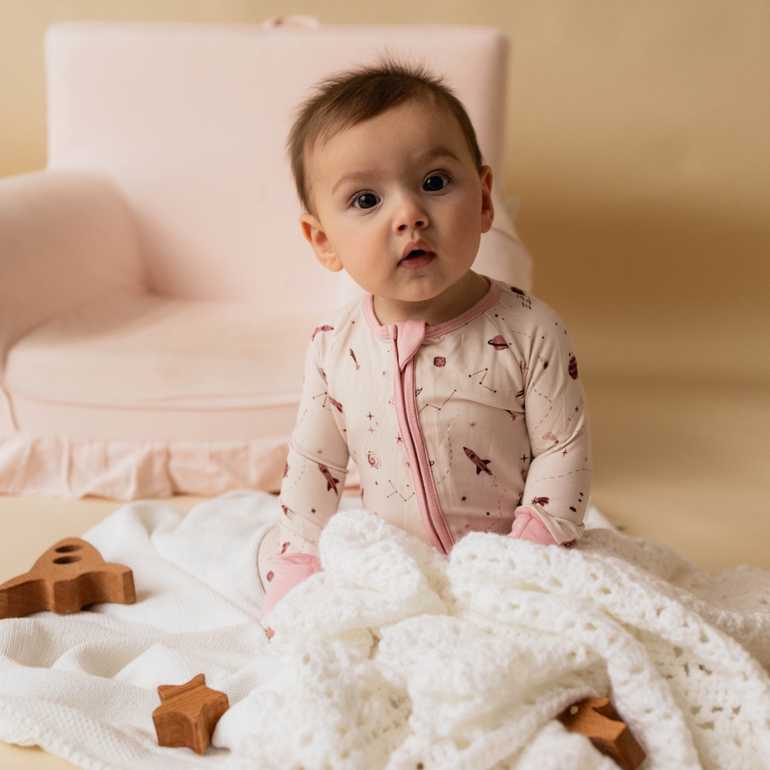 Space baby onesie flat lay — organic cotton with planet and rocket print